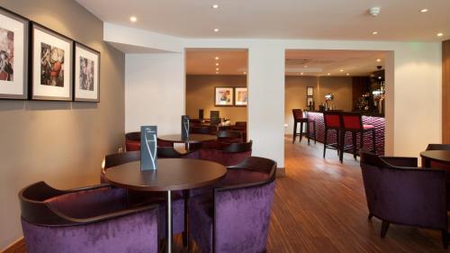 a restaurant with tables and chairs and a bar at Aubrey Park Hotel in Hemel Hempstead