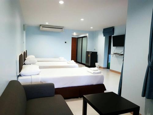 a hotel room with two beds and a couch at Sophia Resort in Ban Wang Takhrai
