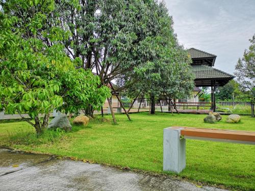 a park with a bench and trees and a gazebo at Sophia Resort in Ban Wang Takhrai