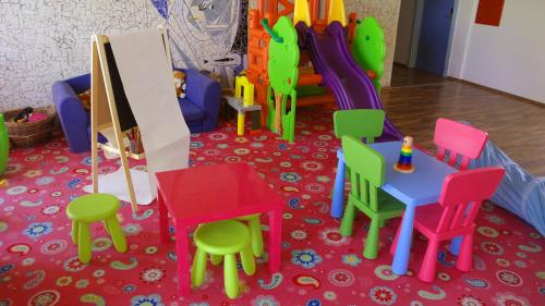 a play room with colorful chairs and a table and chairs at Hotel Lido in Siófok