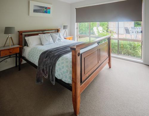 a bedroom with a bed and a large window at Mornington Peninsula-4Shore Rosebud in Rosebud