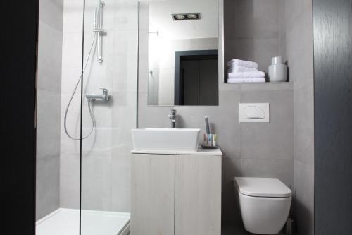 a bathroom with a sink and a toilet and a mirror at Hotel Cubis in Lendava