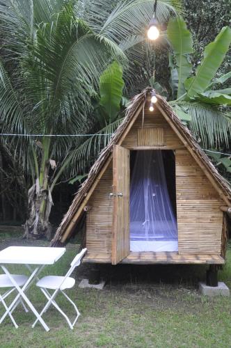 a small wooden hut with a table and chairs at Plantacion Isabelle in Taal