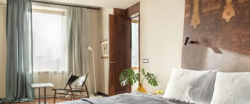 a bedroom with a bed and a chair and a window at Hotel Warszawa in Warsaw