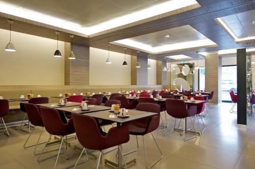 a restaurant with tables and chairs in a room at Mercure Roma Centro Colosseo in Rome