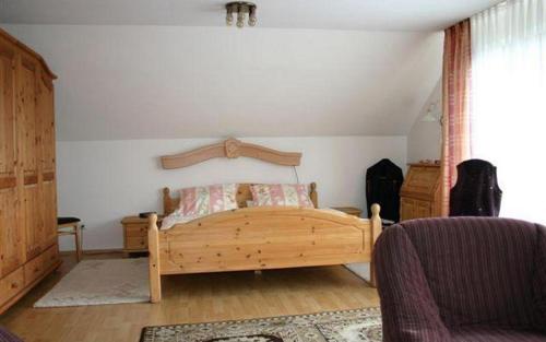 ein Schlafzimmer mit einem Holzbett in einem Zimmer in der Unterkunft Pension Haus zum Schlehenberg in Bayreuth