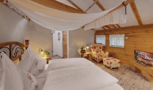 a bedroom with two white beds and a tv at Mohrs Herzl Chalet in Werder