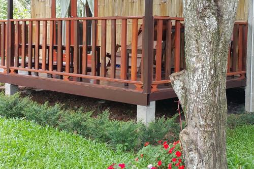 a wooden bench sitting next to a tree at Chiang Dao Reset in Chiang Dao