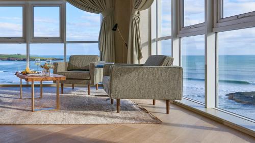a living room with chairs and a table and windows at Inchydoney Island Lodge & Spa in Clonakilty
