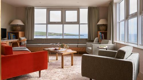 a living room with a couch and chairs and a table at Inchydoney Island Lodge & Spa in Clonakilty