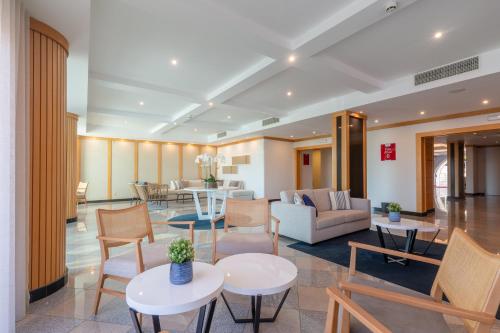 a lobby of a hotel with tables and chairs at The Navigator - Solaqua in Albufeira