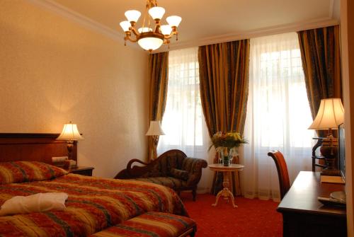 a hotel room with a bed and a chair at Aqua Marina in Karlovy Vary