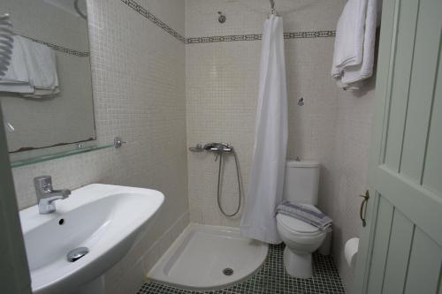 a bathroom with a sink and a toilet and a shower at Nostos Hotel in Chania