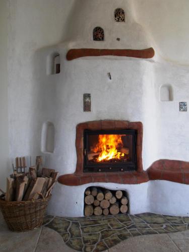 a stone fireplace with a fire in it at Harmonia Mundi in Vlaha