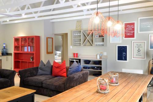a living room with a table and a couch at Ocean Breeze by The Oyster Collection in Kenton on Sea