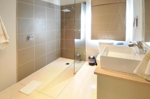 a bathroom with a shower and a white sink at Ocean Breeze by The Oyster Collection in Kenton on Sea