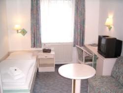 ein Hotelzimmer mit einem Bett und einem TV in der Unterkunft Apart Hotel Taucha in Taucha