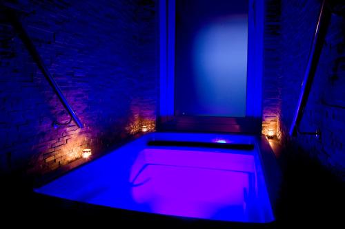 a bath tub with purple lights in front of a window at Penzion Tenis HTK in Třebíč