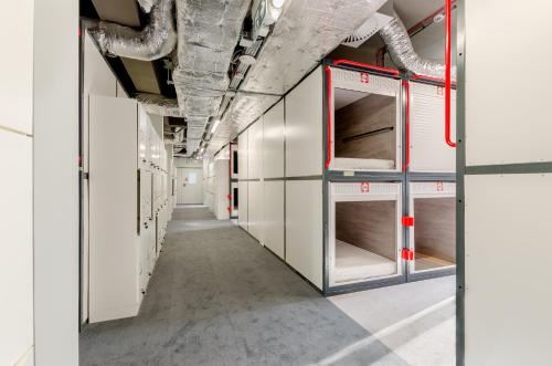 an empty locker room with white cabinets and pipes at Kapsuła Hostel Warszawa in Warsaw