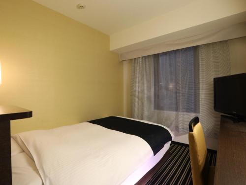 een hotelkamer met een bed en een raam bij APA Hotel Tokyo Kudanshita in Tokyo