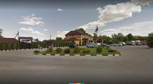 a parking lot in front of a house with cars parked at Fortetsya in Khmelʼnytsʼkyy