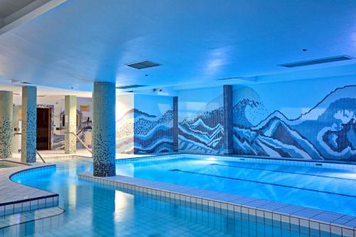 una piscina con un mural de montaña en la pared en Hotel Central Sarajevo, en Sarajevo