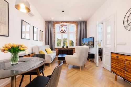 a living room with a table and chairs at Apartments Starowislna Kazimierz Cracow by Renters in Krakow