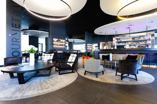 a restaurant with a table and chairs and a bar at Novotel Basel City in Basel