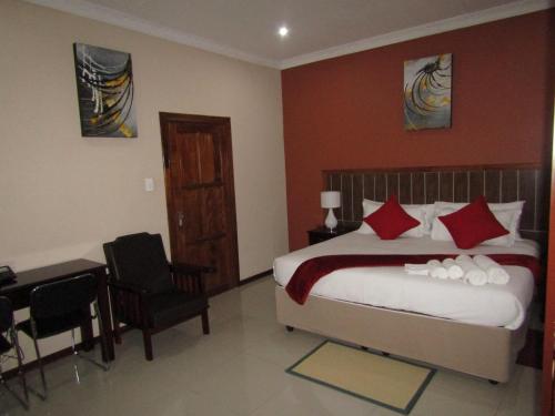 a hotel room with a bed and a desk and a desk at Vido Lodge and Conference Centre in Polokwane