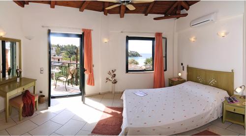 a bedroom with a bed and a view of the ocean at Kalogria Villas in Stoupa