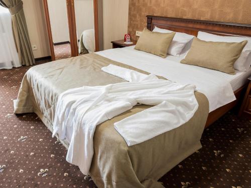 a bedroom with a large bed with white sheets at ArcadiaSky in Odesa