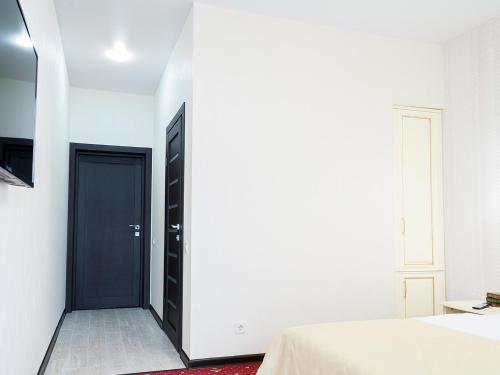 a bedroom with a black door in a white wall at ArcadiaSky in Odesa