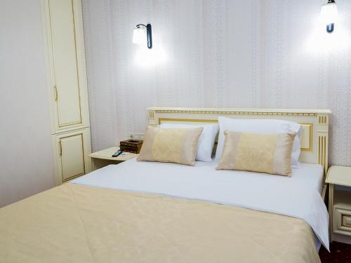 a bedroom with a white bed with two pillows at ArcadiaSky in Odesa