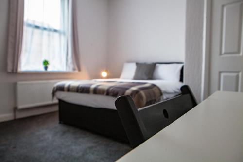 um quarto com uma cama num quarto com uma janela em Maritime Apartments em Barrow in Furness