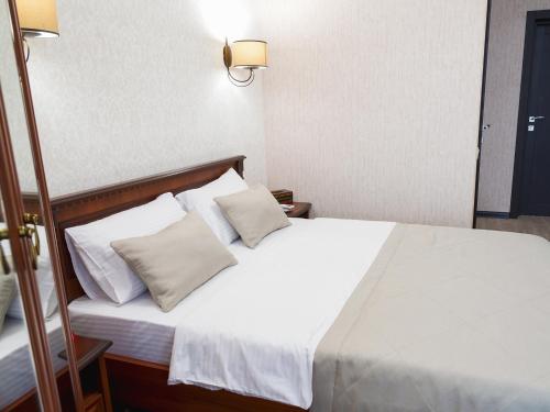 a bedroom with a bed with white sheets and pillows at ArcadiaSky in Odesa