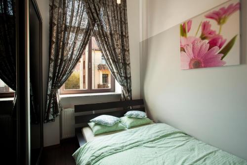 イェレニャ・グラにあるApartament Park Sudeckiの小さなベッドルーム(ベッド1台、窓付)