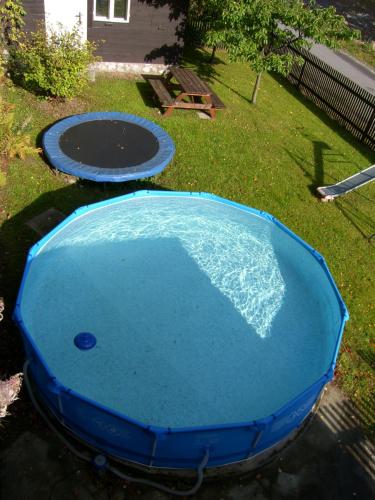 une piscine d'eau bleue à côté d'un trampoline dans l'établissement Holiday Villa Herlikovice, à Vrchlabí