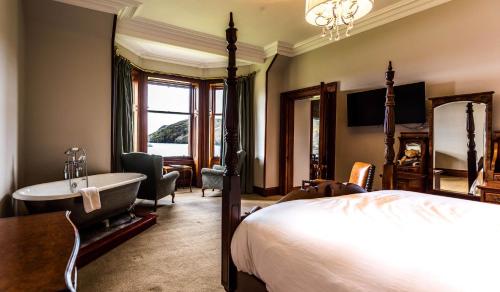 
a bedroom with a large bed and a large window at Shieldaig Lodge Hotel in Gairloch
