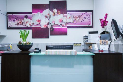a kitchen with a counter with flowers on the wall at Hotel Titus City Centre in Amsterdam