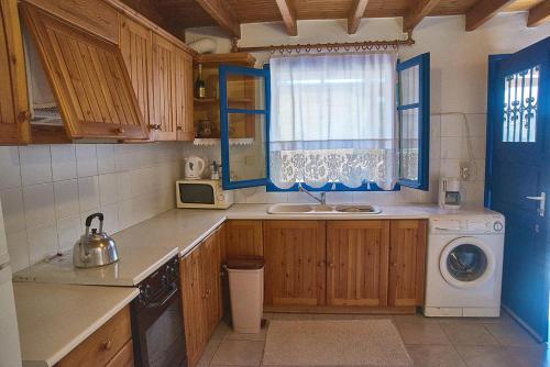 a kitchen with a sink and a washing machine at Almyriki in Methana