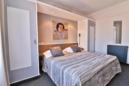 Un pat sau paturi într-o cameră la Hôtel le Chardon Bleu