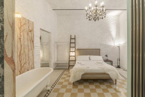 een badkamer met een bed, een bad en een kroonluchter bij Romantic Vintage Colosseum Suite in Rome