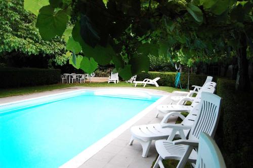 a group of white chairs sitting next to a swimming pool at Casa de Esteiro in Caminha