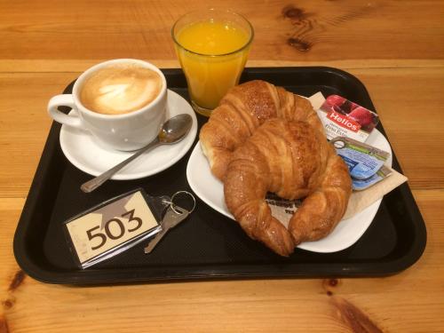 a black tray with a plate of croissants and a cup of coffee at Hostal Los Chopos in Osorno
