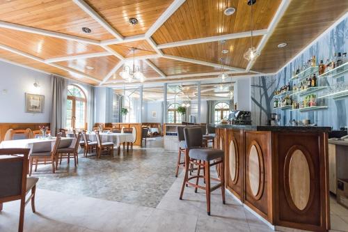 a restaurant with wooden ceilings and tables and chairs at Gościniec pod Bukiem in Głuchołazy