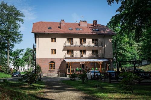 a large house with a balcony on the side of it at Gościniec pod Bukiem in Głuchołazy