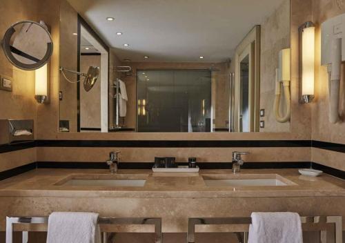 a bathroom with two sinks and a large mirror at FH55 Grand Hotel Palatino in Rome