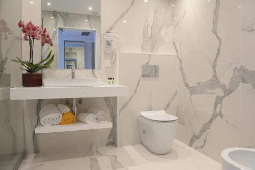 bagno con servizi igienici, lavandino e specchio di Ocean Gardens a Funchal