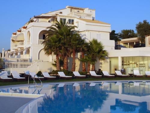 a building with a swimming pool in front of a building at Villa Coppitella, rooms & apartments in Vieste