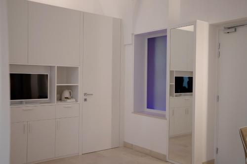 a white room with white cabinets and a window at MONUN Hotel&Spa in Grottaglie